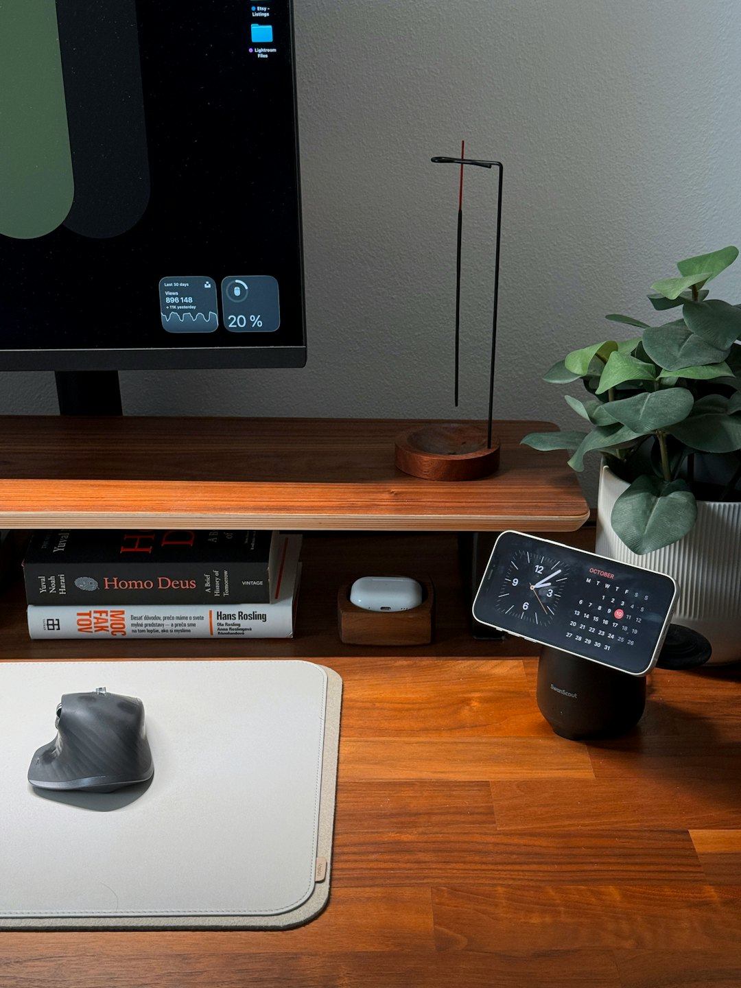 Scrivania moderna in legno con monitor del computer e accessori per ufficio organizzati.